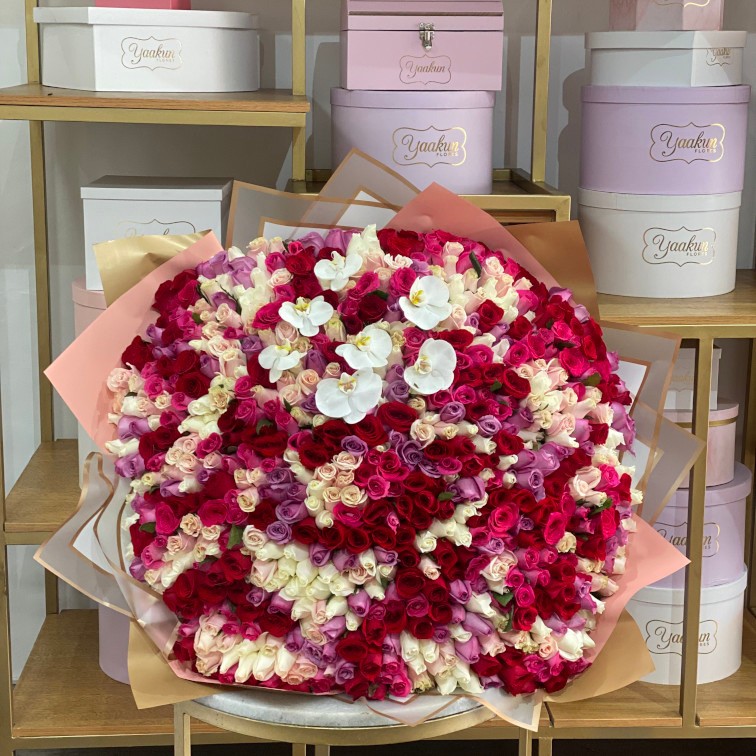 Maxi ramo de 500 rosas en tonos pastel y toques rojos y 7 orquideas phalenosis blancas en papel coreano