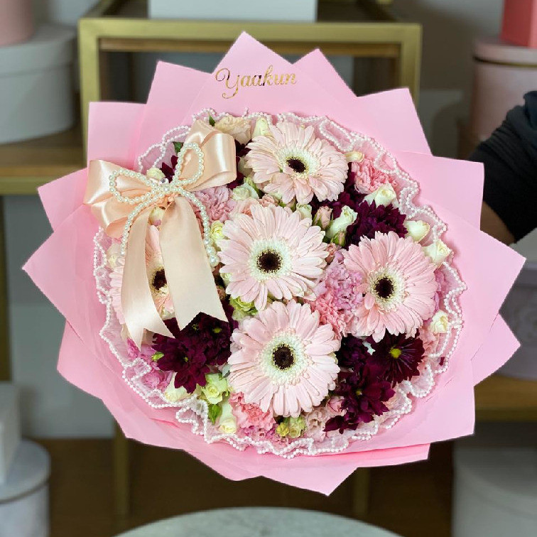 Bouquet con 6 gerberas rositas, baby rose, lisianthus y toques de flores tintas con papel coreanos maya y moño de perlas
