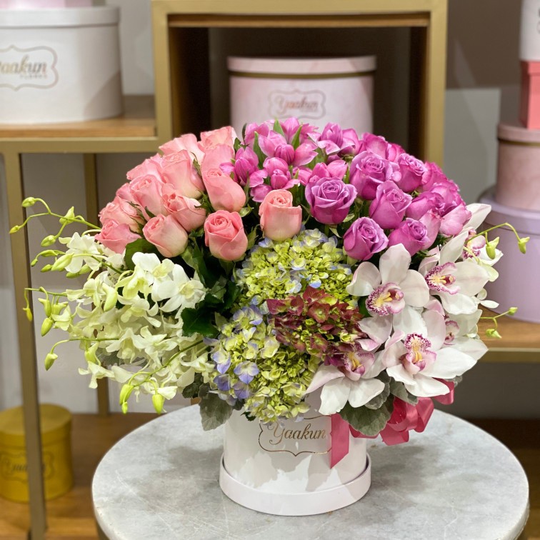 CAJA BLANCA CIRCULAR CHICA CON 50 ROSAS, TULIPANES, DENDROVUIM, CYMBIDIUM, HORTENSIAS