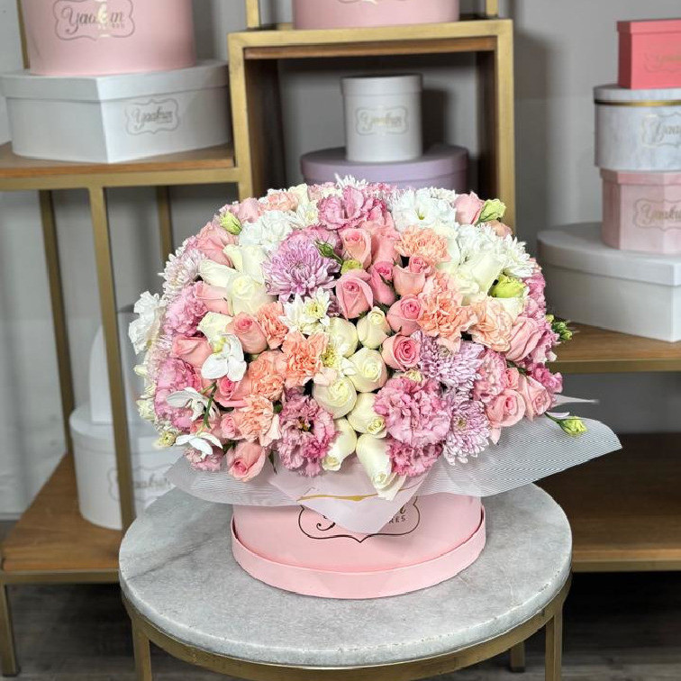 Caja circular rosita con 100 rosas, lisianthus, clavel, roxanas y orquídeas