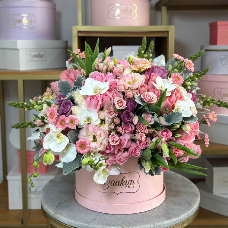 Caja rosita circular con 100 rosas en tonos rosas y toques de orquídea