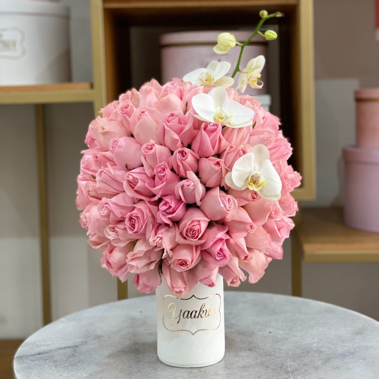 Jarrón de barro blanco con 120 rosas rositas y toques de orquídea blanca phalenosis