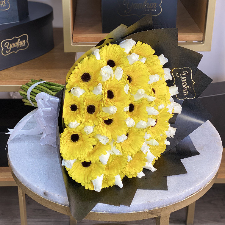 Ramo de 24 gerberas amarillas y 50 rosas blancas con papel coreano